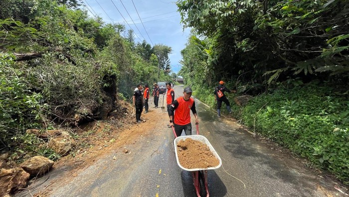 Saat tim gabungan melakukan evakuasi terhadap material tanah yang menutupi jalan