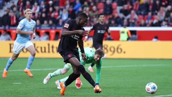 LEVERKUSEN, GERMANY - OCTOBER 04: Christian Kofane of Bayer Leverkusen scores his teams second goal past goalkeeper Frederik Ronnow of 1.FC Union Berlin during the Bundesliga match between Bayer 04 Leverkusen and 1. FC Union Berlin at BayArena on October 04, 2025 in Leverkusen, Germany. (Photo by Lars Baron/Getty Images)