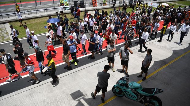 Penggemar berjalan saat pit lane walk MotoGP Indonesia 2025 di Sirkuit Internasional Pertamina Mandalika, Lombok Tengah, Nusa Tenggara Barat, Sabtu (4/10/2025). Pit lane walk merupakan ajang bagi penggemar MotoGP untuk berjalan di pit lane serta melihat lebih dekat sepeda motor pembalap dan aktivitas di paddock tim saat acara MotoGP berlangsung. ANTARA FOTO/Akbar Nugroho Gumay/tom.
