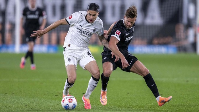 05 October 2025, North Rhine-Westphalia, Mönchengladbach: Soccer: Bundesliga, Borussia Mönchengladbach - SC Freiburg, Matchday 6, Stadion im Borussia-Park: Kevin Diks (Bor. Mönchengladbach) (l) and Lucas Höler (SC Freiburg) fight for the ball. Photo: David Inderlied/dpa - IMPORTANT NOTE: In accordance with the regulations of the DFL German Football League and the DFB German Football Association, it is prohibited to utilize or have utilized photographs taken in the stadium and/or of the match in the form of sequential images and/or video-like photo series. (Photo by David Inderlied/picture alliance via Getty Images)