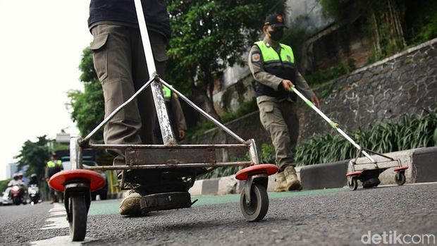 Petugas Satuan Polisi Pamong Praja (Satpol PP) Kelurahan Bendungan Hilir (Benhil) kembali melakukan giat rutin menjaring ranjau paku di sepanjang Jalan Gatot Subroto, Jakarta, Senin (6/10/2025).