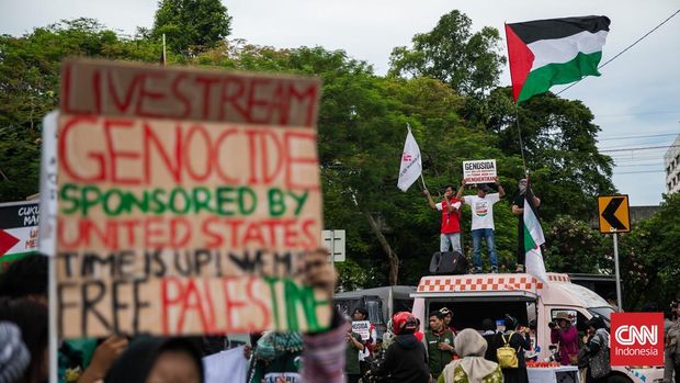 Ratusan massa aksi solidaritas memperingati dua tahun genosida di Gaza menggelar aksi di depan Kedutaan Besar Amerika Serikat (AS), Jalan Medan Merdeka Selatan, Jakarta Pusat, Selasa (7/10/2025). (CNN Indonesia/Adi Ibrahim)