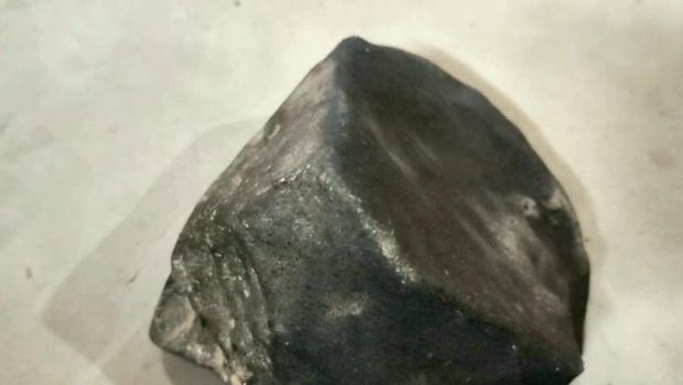 Warga Tegal, Masroni menunjukkan batu yang diduga meteor.