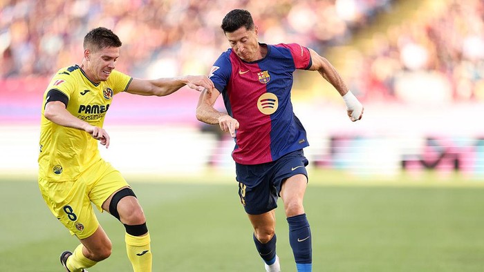 BARCELONA, SPAIN - MAY 18: Robert Lewandowski of FC Barcelona  is put under pressure by Juan Foyth  of Villarreal CF during the La Liga EA Sports match between FC Barcelona and Villarreal CF at Estadi Olimpic Lluis Companys on May 18, 2025 in Barcelona, Spain. (Photo by Flor Tan Jun/Getty Images)