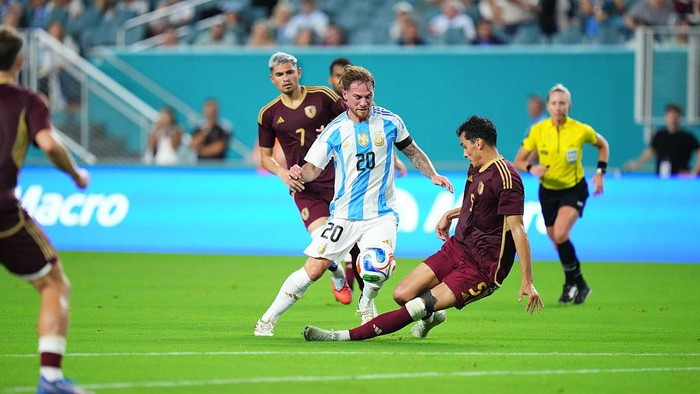 MIAMI GARDENS, FLORIDA - OCTOBER 10: Alexis Mac Allister of Argentina is challenged by Teo Quintero of Venezuela during the International Friendly between Argentina and Venezuela at Hard Rock Stadium on October 10, 2025 in Miami Gardens, Florida. (Photo by Rich Storry/Getty Images)