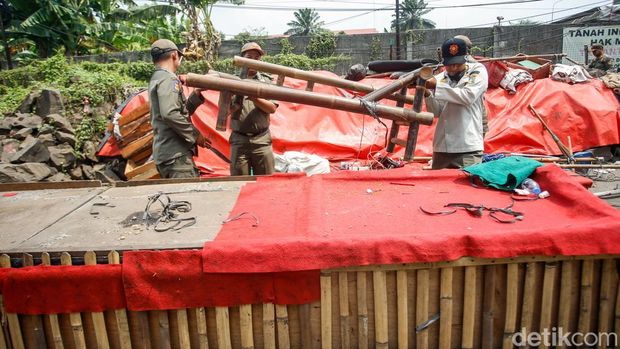 Sejumlah petugas Satpol PP membongkar lapak pedagang liar di Jalan Laksamana Malahayati, Duren Sawit, Jakarta Timur, Rabu (15/10/2025).