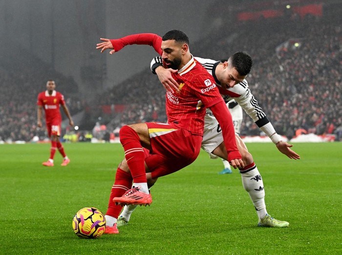 LIVERPOOL, ENGLAND - JANUARY 05: (THE SUN OUT, THE SUN ON SUNDAY OUT) Mohamed Salah of Liverpool is challenged by Diogo Dalot of Manchester United during the Premier League match between Liverpool FC and Manchester United FC at Anfield on January 05, 2025 in Liverpool, England. (Photo by Liverpool FC/Liverpool FC via Getty Images)