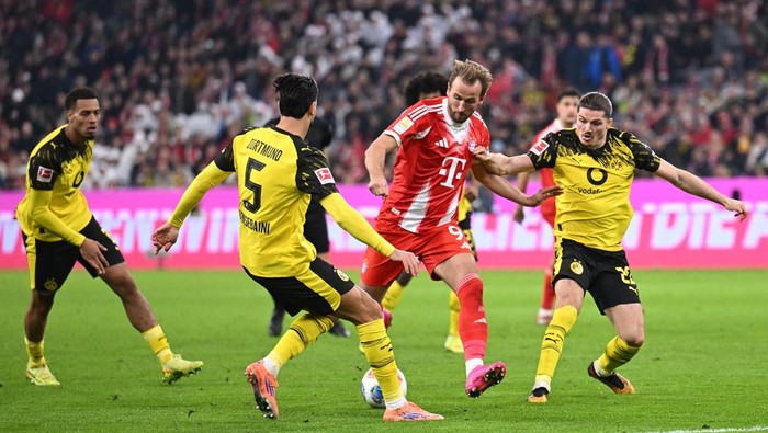 Soccer Football - Bundesliga - Bayern Munich v Borussia Dortmund - Allianz Arena, Munich, Germany - October 18, 2025 Bayern Munichs Harry Kane in action with Borussia Dortmunds Marcel Sabitzer and Ramy Bensebaini REUTERS/Angelika Warmuth DFL REGULATIONS PROHIBIT ANY USE OF PHOTOGRAPHS AS IMAGE SEQUENCES AND/OR QUASI-VIDEO.