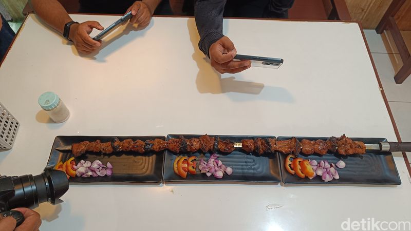 Penampakan sate kambing tusuk pedang sepanjang 1 meter di outlet sate KMC, Purwokerto Utara, Kabupaten Banyumas, Senin (20/10/2025).