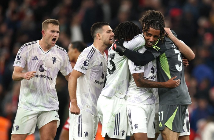 Manchester United Soccer Football - Premier League - Liverpool v Manchester United - Anfield, Liverpool, Britain - October 19, 2025 Manchester United's Patrick Dorgu, Leny Yoro and Senne Lammens celebrate after the match REUTERS/Phil Noble EDITORIAL USE ONLY. NO USE WITH UNAUTHORIZED AUDIO, VIDEO, DATA, FIXTURE LISTS, CLUB/LEAGUE LOGOS OR 'LIVE' SERVICES. ONLINE IN-MATCH USE LIMITED TO 120 IMAGES, NO VIDEO EMULATION. NO USE IN BETTING, GAMES OR SINGLE CLUB/LEAGUE/PLAYER PUBLICATIONS. PLEASE CONTACT YOUR ACCOUNT REPRESENTATIVE FOR FURTHER DETAILS..
