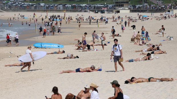 Orang-orang berjemur di Pantai Bondi, lantaran suhu diperkirakan mencapai puncaknya 39 derajat Celsius, menurut Biro Meteorologi, di Sydney, Australia, 22 Oktober 2025. (REUTERS/Hollie Adams)