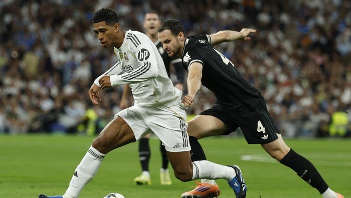 Soccer Football - UEFA Champions League - Real Madrid v Juventus - Santiago Bernabeu, Madrid, Spain - October 22, 2025 Real Madrids Jude Bellingham in action with Juventus Federico Gatti REUTERS/Susana Vera
