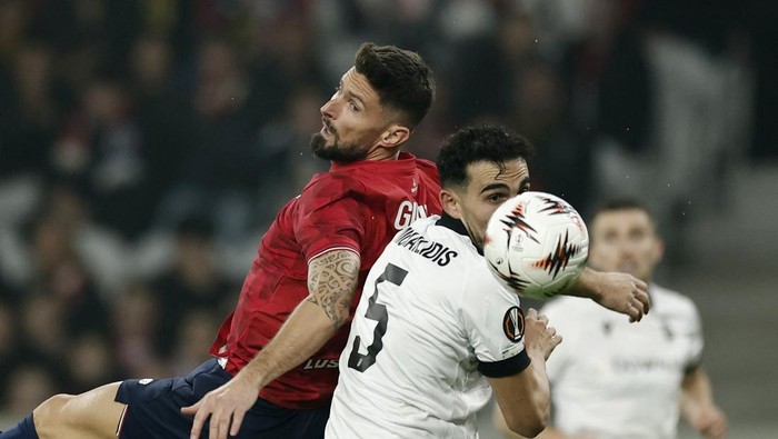 Soccer Football - UEFA Europa League - Lille v PAOK - Decathlon Arena Stade Pierre-Mauroy, Villeneuve-dAscq, France - October 23, 2025 PAOKs Ioannis Michailidis in action with Lilles Olivier Giroud REUTERS/Benoit Tessier