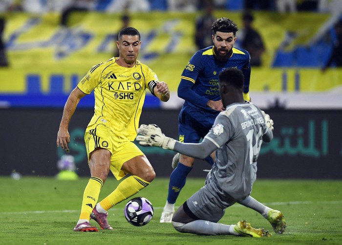 Soccer Football - Saudi Pro League - Al Hazem v Al Nassr - King Abdullah Sport City Stadium, Buraydah, Saudi Arabia - October 25, 2025 Al Nassrs Cristiano Ronaldo in action with Al Hazems Bruno Varela REUTERS/Stringer
