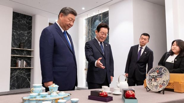 Presiden Korea Selatan Lee Jae Myung memberikan hadiah kepada Presiden China Xi Jinping setelah pertemuan mereka di Gyeongju, Korea Selatan, 1 November 2025. (The Presidential Office/Yonhap/via REUTERS)