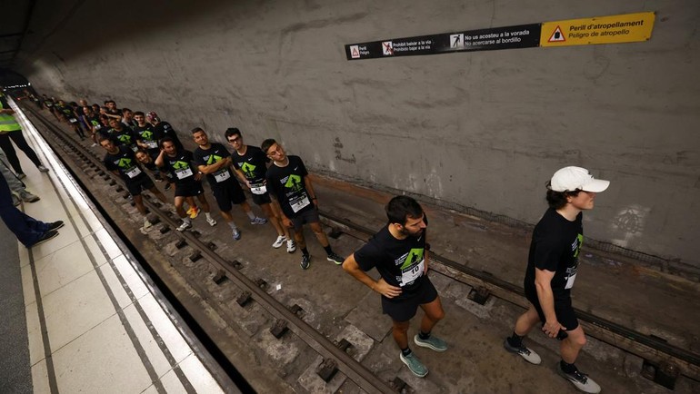 Para pelari berbaris di garis start di dalam terowongan, sebelum melesat di jalur yang biasanya dilintasi kereta. REUTERS/Albert Gea