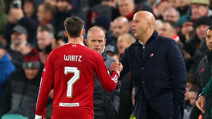 LIVERPOOL, ENGLAND - NOVEMBER 04: Florian Wirtz of Liverpool shakes hands with coach Arne Slot as he leaves the field after being substituted during the UEFA Champions League 2025/26 League Phase MD4 match between Liverpool FC and Real Madrid C.F. at Anfield on November 04, 2025 in Liverpool, England. (Photo by Chris Brunskill/Fantasista/Getty Images)