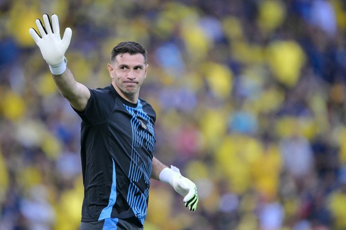 (FILES) Argentinas goalkeeper Emiliano Martinez waves during a warmup ahead of the 2026 FIFA World Cup South American qualifiers football match between Ecuador and Argentina at the Monumental Banco Pichincha Stadium in Guayaquil, Ecuador on September 9, 2025. Goalkeeper for the world champion team, Emiliano Dibu Martnez is not among those called up and appears to be the big name missing from Argentinas friendly football match against Angola in Luanda on November 14, 2025. (Photo by Rodrigo BUENDIA / AFP)