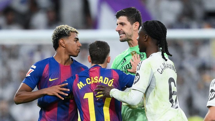 MADRID, SPAIN - OCTOBER 26: Lamine Yamal of FC Barcelona is held back by Marc Casado of FC Barcelona as players of Real Madrid Thibaut Courtois and Eduardo Camavinga of Real Madrid clash with him after the LaLiga EA Sports match between Real Madrid CF and FC Barcelona at Estadio Santiago Bernabeu on October 26, 2025 in Madrid, Spain. (Photo by David Ramos/Getty Images)