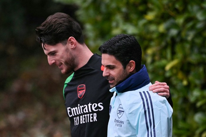 Arsenals English midfielder #41 Declan Rice (L) and Arsenals Spanish manager Mikel Arteta (R) speak together as they arrive to take part in a training session at the Arsenal Training centre in Shenley, north of London on December 10, 2024 on the eve of their UEFA Champions League football match against Monaco. (Photo by Glyn KIRK / AFP)