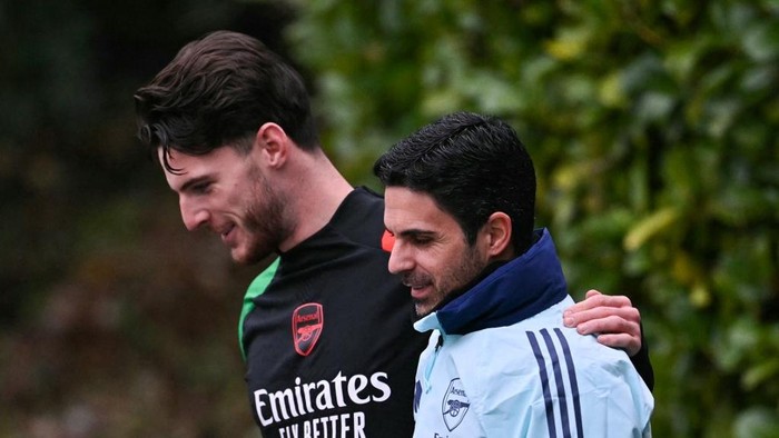 Arsenals English midfielder #41 Declan Rice (L) and Arsenals Spanish manager Mikel Arteta (R) speak together as they arrive to take part in a training session at the Arsenal Training centre in Shenley, north of London on December 10, 2024 on the eve of their UEFA Champions League football match against Monaco. (Photo by Glyn KIRK / AFP)