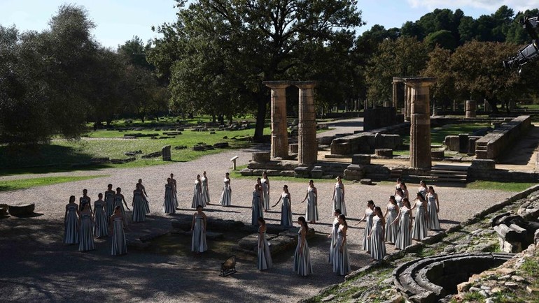 Mengenakan busana bergaya Yunani kuno, mereka mempraktikkan gerakan ritual penyalaan api yang sejak ribuan tahun lalu menjadi simbol perdamaian, sportivitas, dan persatuan di antara bangsa-bangsa.REUTERS/Louisa Gouliamaki