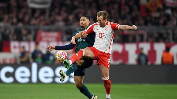 MUNICH, GERMANY - APRIL 17: William Saliba of Arsenal and Harry Kane of Bayern Munich battle for possession during the UEFA Champions League quarter-final second leg match between FC Bayern München and Arsenal FC at Allianz Arena on April 17, 2024 in Munich, Germany. (Photo by David Price/Arsenal FC via Getty Images)