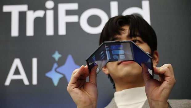 A model poses for photographs with a Galaxy Z TriFold during an event at its store in Seoul, South Korea, December 2, 2025.   REUTERS/Kim Hong-Ji