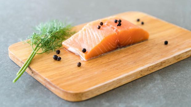 Ilustrasi Fresh Salmon Fillet on board with black peppers