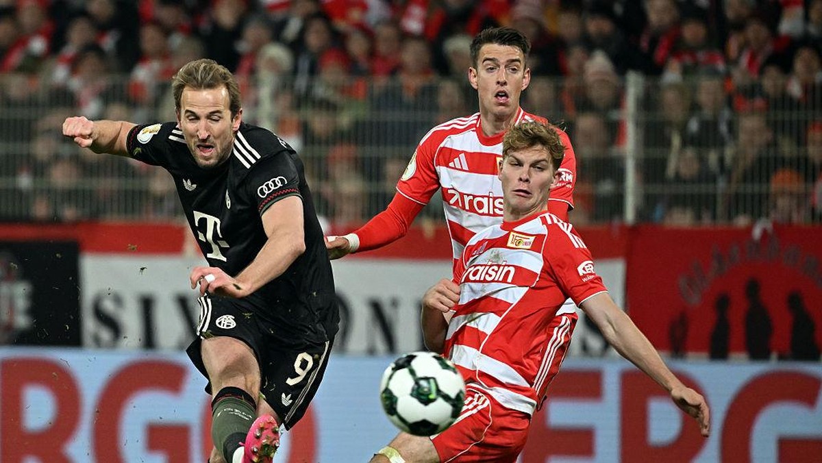 Harry Kane (kiri) dikawal dua pemain Union Berlin saat melepaskan tembakan. Foto: dpa/picture alliance via Getty I/picture alliance