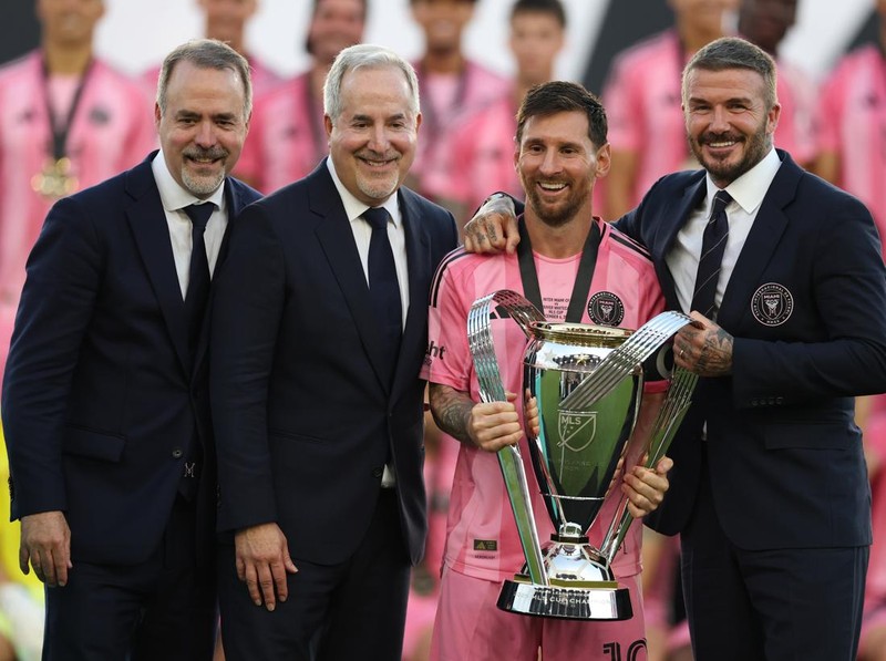 FORT LAUDERDALE, FLORIDA - DECEMBER 06: José Mas, Jorge Mas and Sir David Beckham, co-owners of Inter Miami CF pose with the Champion's trophy next to Lionel Messi #10 after winning the Audi 2025 MLS Cup Final match between Inter Miami CF and Vancouver Whitecaps FC at Chase Stadium on December 06, 2025 in Fort Lauderdale, Florida. (Photo by Maddie Meyer/Getty Images)