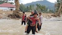 Jembatan Darurat Putus, Polisi Gendong Lansia Seberangi Sungai di Agam