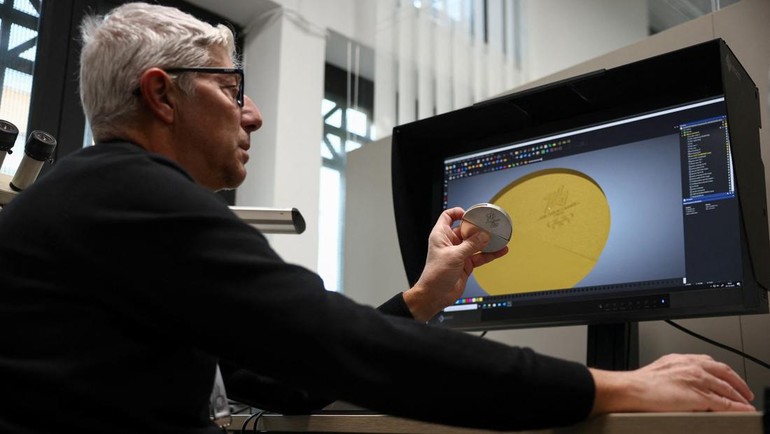 Petugas memeriksa hasil cetakan awal medali emas yang dilapisi enam gram emas murni sesuai pedoman IOC. Kilau setiap medali menjadi simbol dedikasi dan perjuangan panjang para atlet. REUTERS/Guglielmo Mangiapane