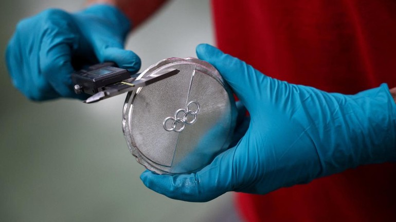 Proses perakitan dua bagian medali “cakram es” yang menjadi ciri khas desain Olimpiade Milano Cortina 2026. Potongan rapi dihubungkan melalui simbol Olimpiade yang berada di bagian tengah. REUTERS/Guglielmo Mangiapane