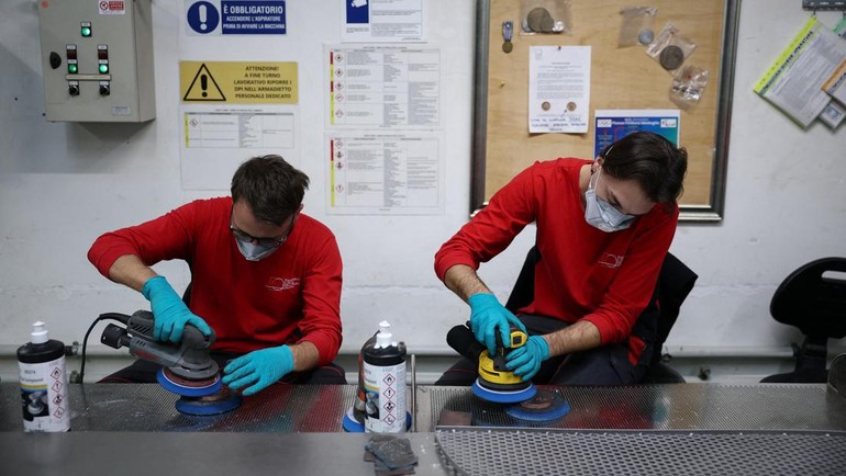 Pekerja IPSZ menghaluskan tekstur buram dan mengkilap pada dua sisi medali, yang melambangkan atlet dan jaringan pendukung di balik kesuksesan mereka. Detail artistik ini dikerjakan dengan presisi tinggi. REUTERS/Guglielmo Mangiapane