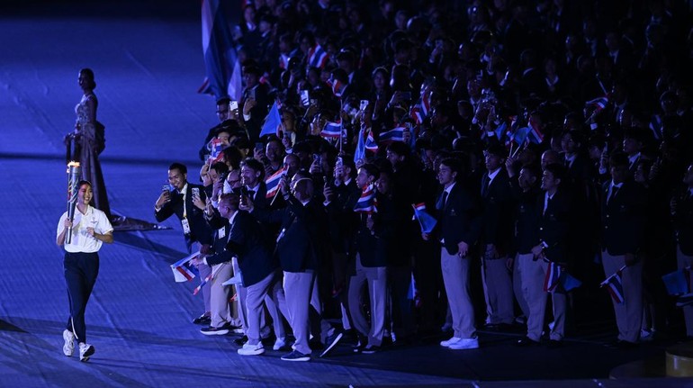 Atlet Taekwondo Thailand Panipak Wongpattanakit (kiri) berlari membawa obor SEA Games saat upacara Pembukaan SEA Games 2025 di Stadion Rajamangala, Bangkok, Thailand, Selasa (9/12/2025). ANTARA FOTO/Nova Wahyudi