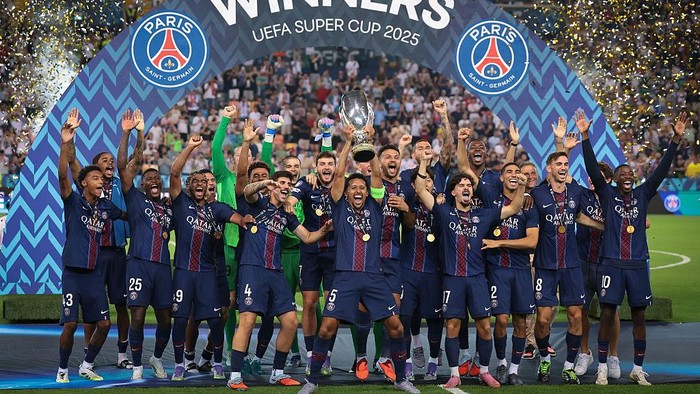 UDINE, ITALY - AUGUST 13: Marquinhos of PSG lifts the trophy as he celebrates with team mates Lucas Chevalier, Achraf Hakimi, Marquinhos, Khvicha Kvaratskhelia, Ousmane Dembele, Desire Doue, Vitinha, Nuno Mendes, Bradley Barcola, Warren Zaire-Emery, 