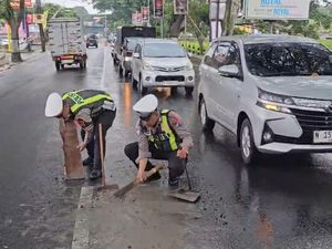 Gercep Personel Satlantas Polres Batu Bersihkan Tumpahan Semen di Jalan