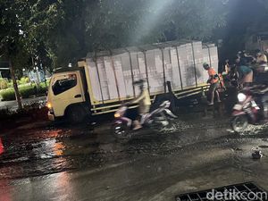 Truk Angkut Bata Ringan Terperosok di Jalan Berlubang Hertasning Makassar