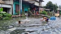 Pegangsaan Dua Jakut Masih Banjir, Jadi Wahana Bermain Dadakan Anak-anak