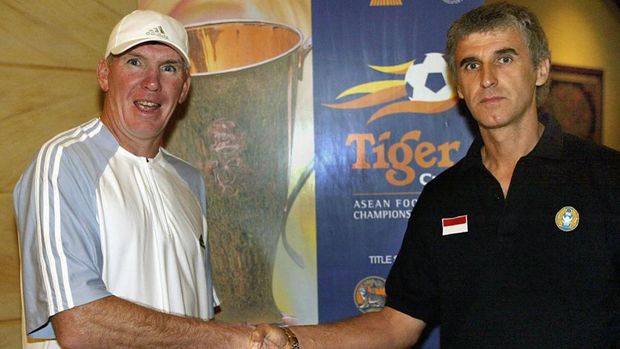 Peter Withe (L), coach of Thailand shakes hands with Ivan Kolev, the coach of Indonesia, as he wishes him the best of luck, 28 December 2002, ahead of their Tiger Cup match-up in Jakarta. Thailand will meet Indonesia 29 December in the final of the Tiger Cup.   AFP PHOTO/WORLD SPORT GROUP/Stanley CHOU (Photo by STANLEY CHOU / WORLD SPORT GROUP / AFP)