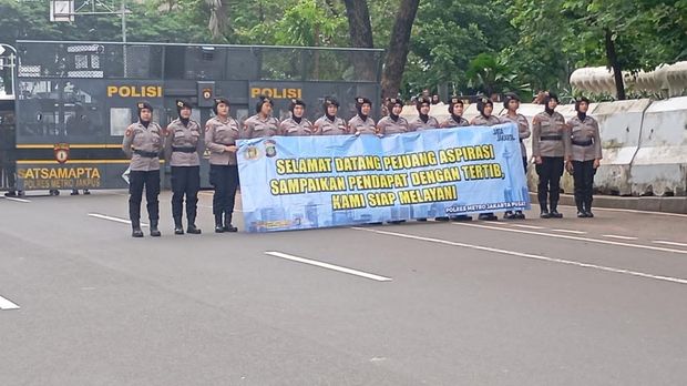 Polwan Polda Metro Jaya memberikan pelayanan humanis kepada massa aksi unjuk rasa dari Dewan Presidium Pusat Koalisi Ojek Online Nasional di silang Monas. (dok Ist)