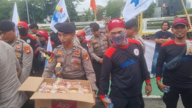 Sejumlah massa buruh menggelar demonstrasi di depan Gedung DPR/MPR RI, Jakarta. Polisi mengamankan sekaligus membagikan air mineral dan snack ke massa buruh. (dok ist)