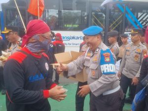 Polisi Bagi Air Mineral dan Snack ke Massa Buruh yang Demo di DPR