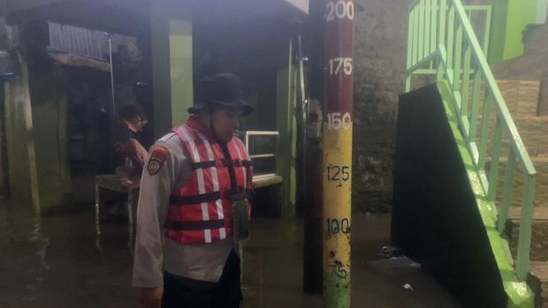 Polisi bantu warga hendak melintasi banjir dengan perahu (dok. Istimewa)