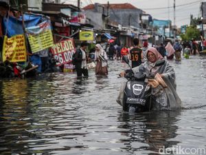 Aksi Nekat Warga Dorong Motor di Tengah Banjir Pondok Ungu Permai Bekasi