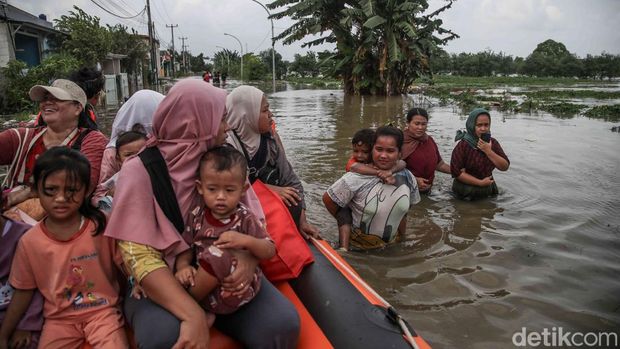 .Eine Reihe von Bewohnern überquerte am Freitag (23.01.2026) die einzige Zufahrtsstraße, die im Gebiet Jalan Raya Sukamekar, Tambun Utara, Bekasi Regency, West-Java, überflutet war. Diese Straße ist ein wichtiger Zugang und die einzige Verbindungsroute zu einer Reihe von Wohngebieten, darunter Green Permata Residence Subsidized Housing, Nebraska, Mutiara Indah Housing sowie mehrere andere subventionierte Wohnungen in der Gegend von North Tambun.