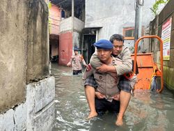 Brimob Polda Metro Gendong Warga Sakit yang Terjebak Banjir di Jakbar