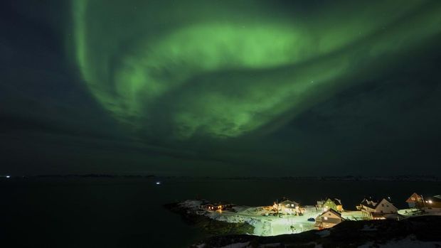 Nyalang Edisi 31 Januari 2026 Aurora borealis lights up the night sky over residential houses in Nuuk, Greenland, on January 23, 2026. (Photo by Jonathan NACKSTRAND / AFP)