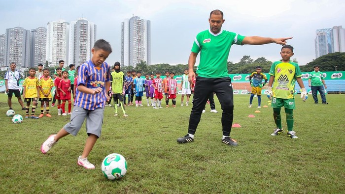 Pesepak bola profesional yang juga penjaga gawang Persija Jakarta Andritany Ardhiyasa (kiri) memberikan pelatihan dasar cara bermain bola yang baik dan benar saat coaching clinic yang menjadi rangkaian babak final MILO National Championship 2026 di Stadion Soemantri Brodjonegoro, Jakarta, Minggu (1/2/2026). Coaching clinic yang diikuti para peserta MILO National Championship 2026, memberikan pelatihan dasar sepak bola, mulai dari passing, ball control, dribbling, hingga aktivitas berbasis permainan dengan melakukan tendangan penalti ke gawang. ANTARA FOTO/Muhammad Iqbal/foc.
